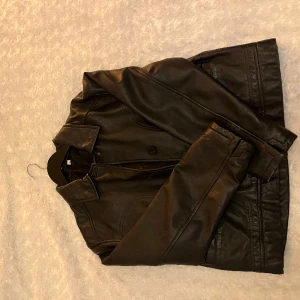 Skinnjacka i äkta läder  - 100% läder (etikett finns på isnida av jacka). Köpt på Humana för ca 500kr sommaren år 2022- gott skick. Blivit för liten för mig.✨ Storlek okänd: liknar storlek S/M