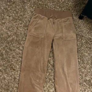 Juicy byxor - Säljer ett par juicybyxor i den beiga färgen! Just nu är de slutsålda på hemsidan. Super bra skick förutom lite smutsiga vid fötterna men inget man tänker på💕