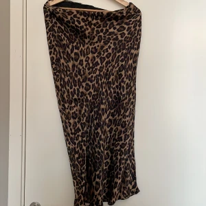 Midikjol - Midikjol i leopardmönster. Glansigt material. Sparsamt använd.