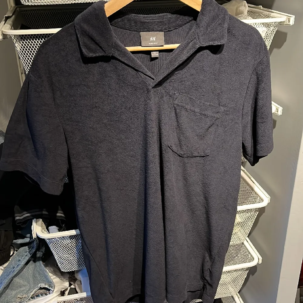 Marinblå mockatröja med en ficka samt krage. T-shirts.