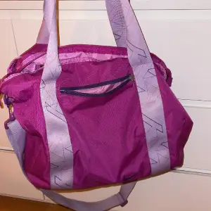 Rosa/lila Nike väska, perfekt till träning/gym. Säljer då jag har en till liknande. Har både långt och korta band. 