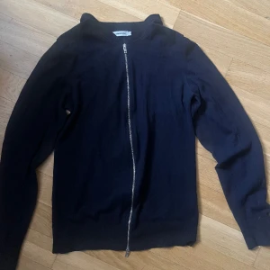 Zip tröja - Säljer denna zip tröja från J.Lindeberg. Då den inte kommer till användning längre! Den är i bra skick utom att den var ett litet hål i ena armhålan.  Skriv gärna vid frågor