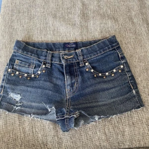 Lågmidjade jeansshorts  - Jättefina jeansshorts som tyvärr inte kommit till användning. Om ni har fler frågor är det bara att kontakta mig❤️ (Knappen på shortsen syns inte på bilden då shortsen är oknäppta, men det finns en knapp)