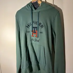 En helt oanvänd Tommy Hilfiger tröja med luva! Det är en sampel produkt vilket innebär att den är sällsynt om inte omöjliga att få tag på! Ny pris 1349kr. Mitt pris 499kr!