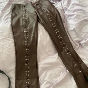 Läderbyxor med snörning - Fejk läder byxor med störning. Storlek 36 men passar 34 bättre. 