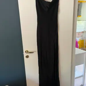 En svart satin balklänning från meshki med en lång slits och en helt öppen rygg! Säljer då jag hittade en annan som passade på min kropp bättre! 😊ALDRIG ANVÄND! kom privat för bilder på