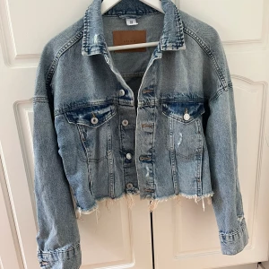 Jeansjacka  - En kortare jeansjacka i ljusblått tyg i storlek XS