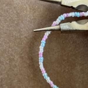 Somrigt armband med vita, rosa och blå pärlor💖Armbandet beställs här på min plick!💞💞  Instagram: jewelixx Tiktok: jewelixxx