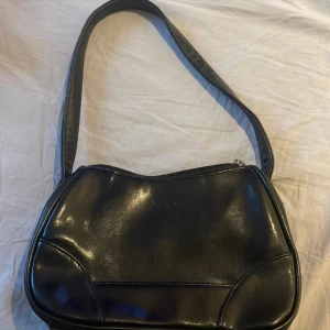 Vintage väska - Liten svart axelremsväska i läder. Man får plats med det nödvändiga, mobil, plånbok, nycklar osv. Men enkel och lätt att ha med sig🤗