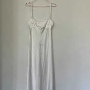Studentklänning - Vit lång klänning från Zara, oanvänd endast testad. Säljer då den är för liten i bysten. Klänningen är storlek L men är liten i storlek och sitter som M 