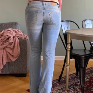 Low waist, bootcut Jeans  - Ljusblå denim, använda men i bra skick. Utsvängda samt låg midja. Size 34 & full lenght. Skön stretch, 67% bomull 33% polyester.   (Övrigt: Jag är 170 cm, strl 36/small så dessa är för små i midjan). 