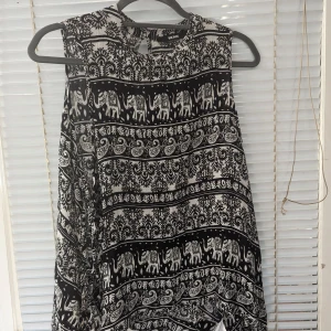 ärmlös tröja från Bik Bok,M - Snygg ärmlös tröja från Bik Bok med öppningar på sidorna som knyts ihop. Storlek M, normal i storlek. Sparsamt använd och i mycket fint skick