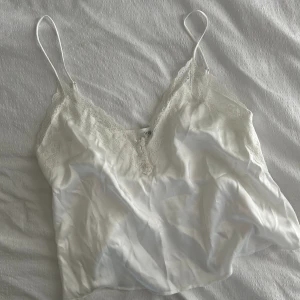 Vitt linne i siden med spets  - Sött litet linne med spets. Aldrig använt, helt i nyskick. Storlek S