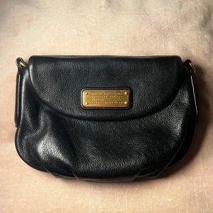 Marc Jacobs väska - Nästan oanvönd Marc Jacobs handväska/shoulder bag! Lädret är helt nytt utan repor. Band kommer med (se 4:de bilden). Slitage inuti väskan men inget som märks på utsidan (se 5:de bilden). Kan skicka fler foton om intresse finns ❤️ original pris: 1000kr