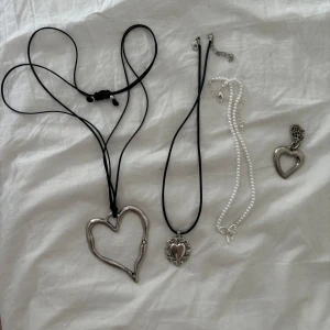 Smycken med hjärtan - ALLA för 120kr!! Inkluderar två halsband med svarta band och hjärtformade hängen, ett halsband med vita pärlor och en rosett samt ett samt en hjärtformad berlock.