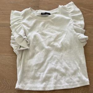 volang topp - vit volangtopp från zara strl M, säljer då den inte kommer till användning längre. Har även i blå och gul strl S om nån vill köpa de färgerna istället!