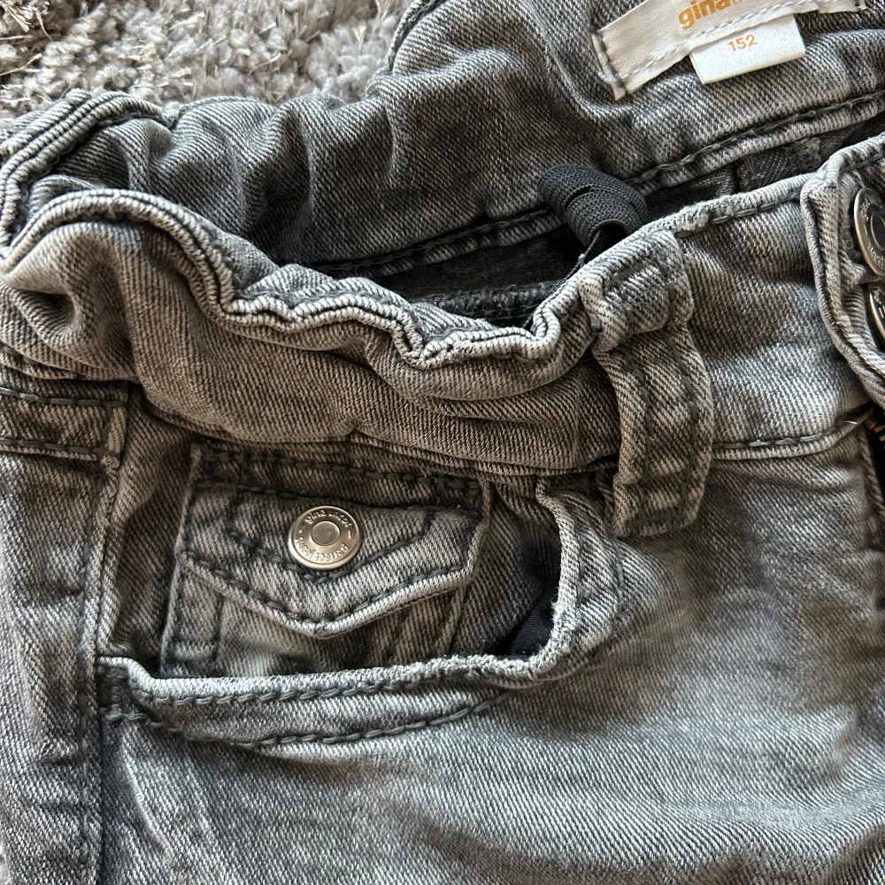 Gråa boodcut jeans ifrån Gina Tricot Young! Jeansen är i bra skick. Jeansen är i strl 152. Säljer därför de börjat bli för korta i benen. . Jeans & Byxor.