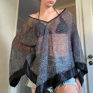 Svart och grå leopardmönstrad poncho - En luftig blus/coverup med leopardmönster. Vida ärmar och en lös passform, perfekt för sommarkvällar eller att ha över en bikini💓Passar alla storlekar beordrade på hur man vill den ska sitta! 