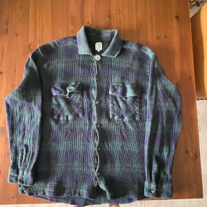 Polar flannel shirt - 2 years Old, good condition. Top button fell off so I glued on a volcom pin to replace it.