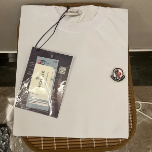 Moncler T shirt - En helt ny och oanvänd Moncler T shirt i färgen Vit. Perfekt skick och sitter mycket fint. Tagg och Qr kod finns som på bild