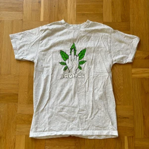 Bronze T-shirt  - Bronze T-shirt med ett fett print. Säljes få den inte kommer till användning längre. Fint skick. Size M 