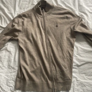 Morris helzip beige - Säljer nu denna svinsnygga Morris Helzip tröjan i merinoull, som köptes på NK för 2000 kr. Den är i storlek S och har inga defekter över huvudtaget. Bara att höra av er vid eventuella frågor 