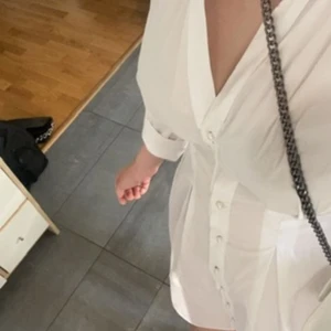 Vit klänning med pärlor - ZARA - Endast använd en gång, i skick som ny. Storlek M, normal i storleken. Fina pärlor vid krage & matchande knappar. Nypris: 450 kr. Vid snabb affär kan pris diskuteras!