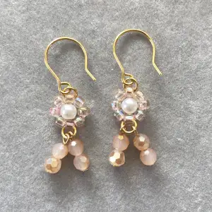 Subtle and sweet floral design in pink and light gold shades. These homemade earrings are created with hand-woven flowers and pink glass beads that sparkle as you move.  Materials Imitation pearls (acrylic) Japanese beads (Toho) Glass beads pink