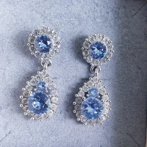 Lily and rose  - Örhängen lily and rose  Endast använda ca 3 ggr  Längd 3.5 cm  Färg light sapphire  Nypris 549 