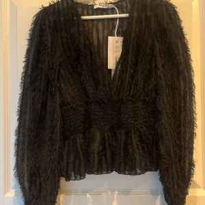 Blus - Så fin och festlig blus med fransar och smockad midja från NA-KD, blusen är i storlek 34 och är i nyskick med prislapp kvar! Nypris är 449 kr🌸