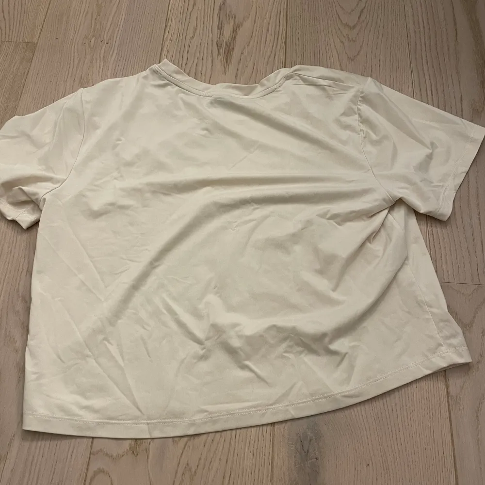 Säljer denna beigea tränings t-shirten från Stronger då den inte kommer till användning. Den är i fint skick och bara använda ca 2 gånger. . T-shirts.