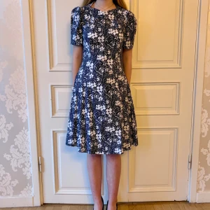 Mönstrad klänning, Emmy design  - Jättefin klänning i skönt material. Fickor! Mönstrad med färgerna svart vit.Storlek 38.  Modellen på bilden är 173 cm och har storlek 38 i de flesta andra kläder. Aldrig använd. Vi har lagt ner vår klänningsbutik och säljer ut. Ny pris är 2000-3000kr