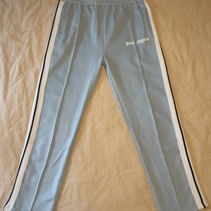 Palm Angels track pants - Track pants Palm Angels Herr strlk. XL Säljer byxorna för jag rensar garderoben och inte använt dem på länge. Köpte byxorna av en kille i USA när jag var på basketläger några år sedan, där av priset. -Midja 43 Cm -Längd 106,5 Cm