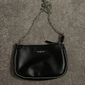 Väska - Säljer denna väska då jag inte använder den och ska flytta. Den är i mycket bra skick då den knappt kommit till användning. Den har 2 olika band ett längre som räcker runt kroppen och ett kortare.  Nypris ca 450kr