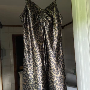 Leopardklänning - Så fin leopardklänning. Mönstrad i leopard och tyget är satin.🌸Miniklänning med fin detalj vi bröstet.