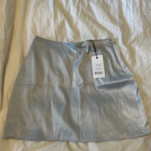 Ljusblå kjol - Ljusblå satinkjol från NA-KD. Ny med prislapp