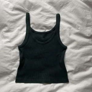 Mörkgrönt brandy Melville linne💗💗 - Jättefint mörkgrönt linne💗det är i storlek one size men jag skulle uppskatta att de är typ xs🫶🫶 skriv gärna till mig om ni har frågor eller är intresserade💗