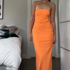 Klänning  - Säljer denna orangea badauklänning med detaljer i ryggen. Använd en gång.