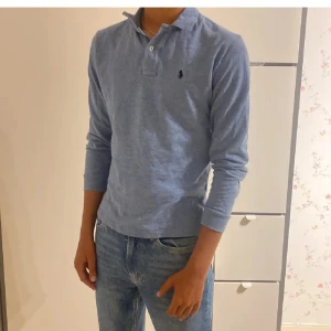 Långärmad piké  - Säljer nu denna snygga och trendiga Polo Ralph Lauren långärmad piké i snygg blå färg. Är i storlek s men passar även m. Är i väldigt bra skick utan defekter. Nypris är ca 1300. Personen på bilden är ca 184cm