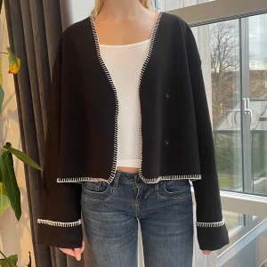 Svart jacka/kofta - Popplulär ”Stitch blanket” från Gina Tricot. Säljer på grund av att den inte riktigt kommer till användning och därför endast använd ett fåtal gånger. Passar mig som vanligtvis har S/M på jackor trots att den är storlek L💞
