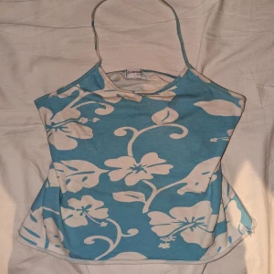 Turkost halternecktop - Jätte fint turkost somrigt halternecktop med vita blommor. Har en liten missfärgning man kan se på bilden