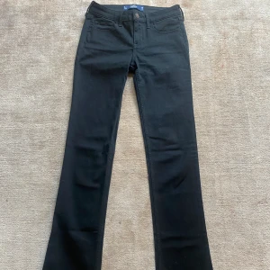 Svarta jeans - Supersnygga svarta lågmidjade bootcut jeans från hollister! Midjemått 32, innerbenslängd 86 cm, mycket bra skick