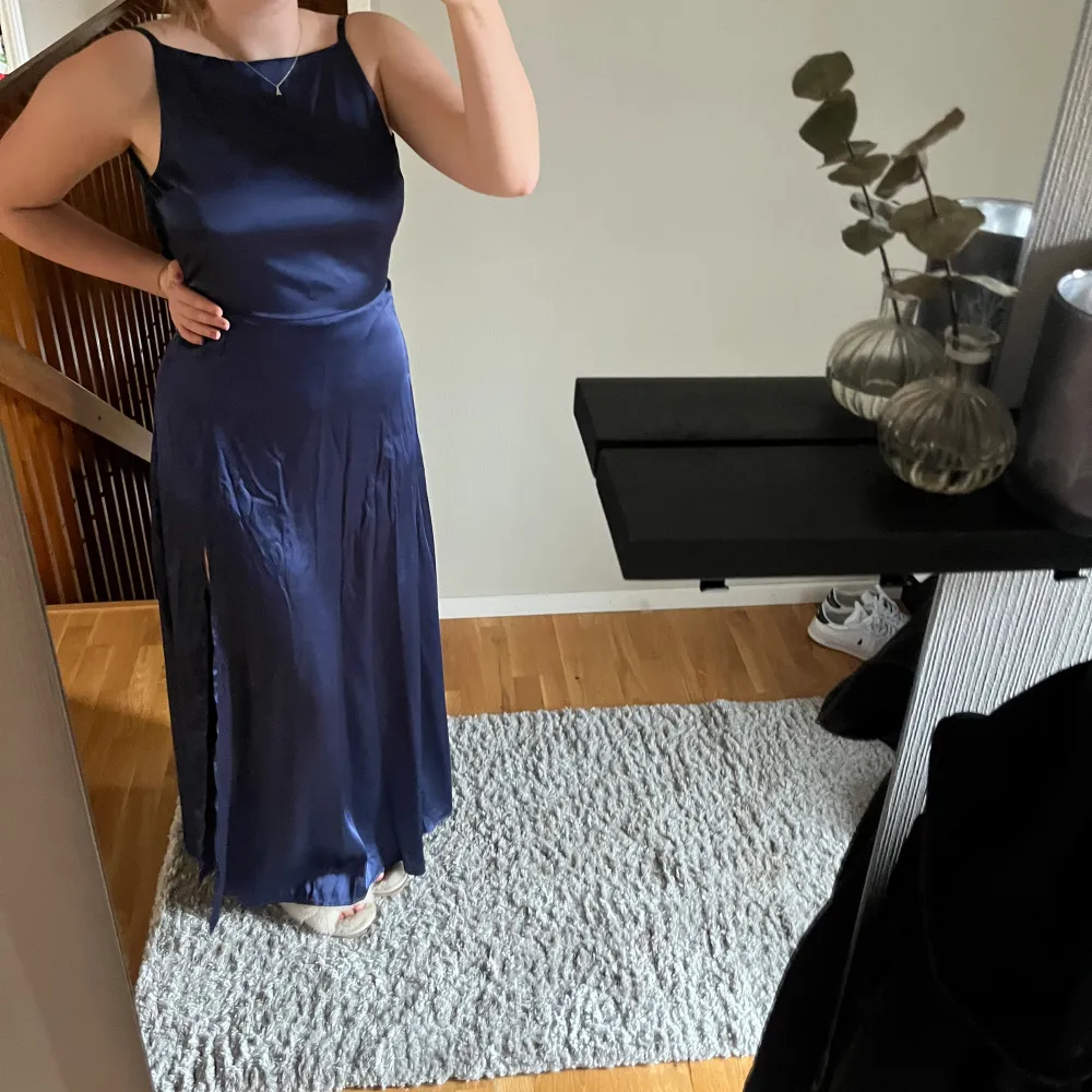 Jag säljer nu min balklänning som jag använt 1 gång på balen i 9:an. Det är en marinblå satin kläning med slits och en öppen rygg med spetsdetaljer💗. Klänningar.