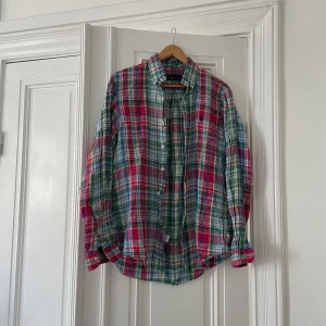 Ralph Lauren linneskjorta  - Mycket fin linneskjorta från Ralph Lauren i ett flerfärgat rutigt mönster.   Storlek S men något längre i size, personen på bilden är 183cm.  Mönstret ”blöder” lite vilket är mycket vanligt på denna typen av skjortor och är inget som märks. 