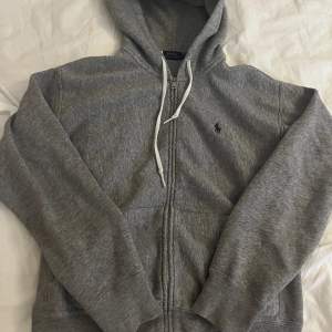 Fin grå hoodie med dragkedja från Ralph Lauren, den är endast använd en gång så den är i nyskick. Storlek M , köptes för 1099kr 