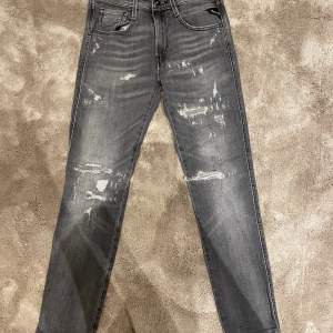 Gråa Replay jeans med slitningar. Modellen på jeansen heter bronny, dem sitter slim fit. Köpta på BestSecret. Bra skick, knappt använda. Priset kan diskuteras