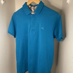 Blå Burberry Piké - Säljer denna blåa burberry piké i bra skick. Storlek L. Kan tänka mig sänka priset lite vid snabb deal. Säljer mycket liknande på min profil.