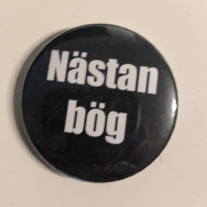 ”Nästan bög” pin - Svart bakgrund med vit text ”nästan bög” 