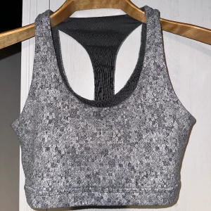 Gymshark Fleur Textured Grey Sport BH XS  - Logo slightly cracked and yellowed, bought it in this condition. Moderately used condition. No tears, rips, holes, stains, fuzz, pilling. No other flaws to note. Disclaimer: Please expect some general wear in all secondhand pre-owned items as they ha