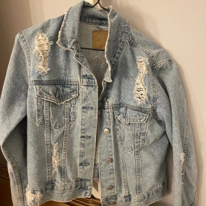 Jeans jacka - En fin blå jeans jacka med hål. Skriv privat för fler bilder.